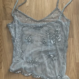 Glitter/paljett linne - Grön/blått linne med paljetter samt fjärilsmotiv. Ej stretch