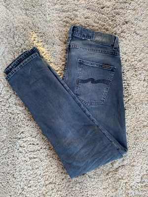 Nudie jeans grim tim - Säljer dessa väldigt trendiga Nudie jeans grim tim. De är i en väldigt snygg svart färg och grå. De är i bra skick och de har ingen skada på dem alls. Är lättåtkomlig och svarar snabbt. Nypris 1600kr, mitt pris 400. 