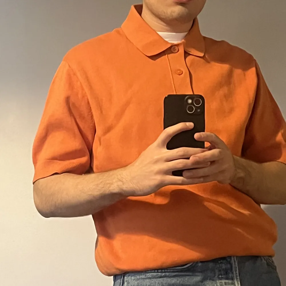 Hi! A short sleeved orange polo from COS. It is a small but fits a medium.  Only worn once and it is made of 100% cotton.. Toppar.