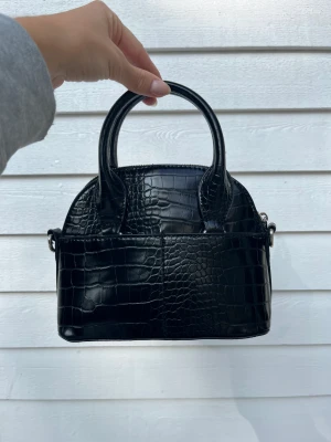 Svart väska från Zara - Svart miniväska från Zara i ormskinnsmönster. Fint skick!