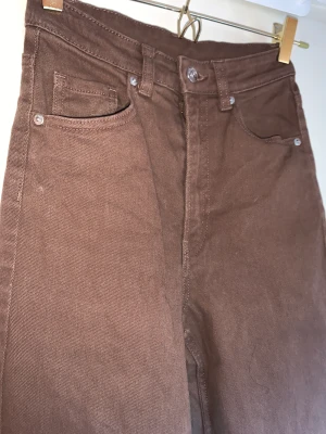 Bruna jeans - Bekväma, något strechtig material som sätter sig bra och inte blir pösigt över dagen. Följer kurvor fint, utsvängda ben, högmidjade. Använda fåtal gånger.