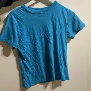 En blå tshirt perfekt för alla outfits! Tveka inte att skriva för fler frågor 