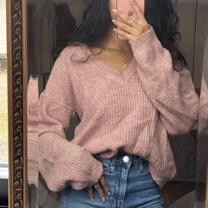 Stickad rosa tröja  - Stickad vringad tröja i en naturlig rosa färg från nakd. Tröjan är lite nopprig men inget som syns särskilt mycket.