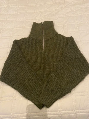 Stickad tröja - Stickad tröja från Gina tricot i en jätte fin höstig grön färg. Den är lite croppad, jätte snygg med lågmidjade jeans. Jätte bra skick. Storlek XS men den är lite oversized så den sitter bra på mig som har storlek S