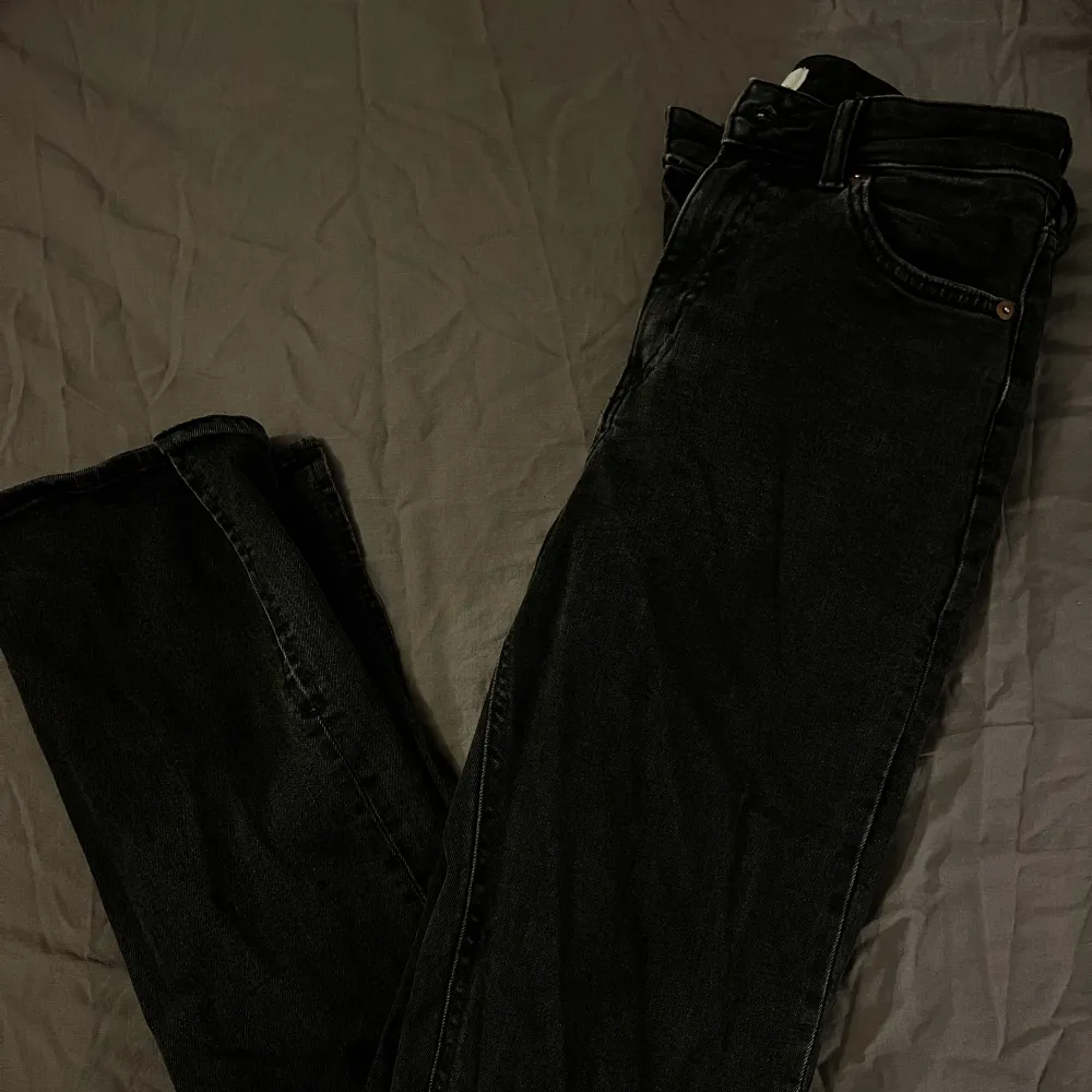 ett par svarta/gråa jeans med slits ifrån hm . Jeans & Byxor.