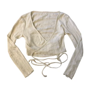 Stickad topp - Söt stickad topp som knyts i ryggen. Den är i använt skick så har några små hål men är inget som märks av.