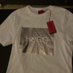 Vit/silver t-shirt från Hugo Boss. Aldrig använd. Ny pris 600. Priset kan diskuteras!