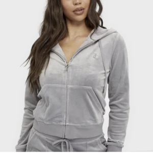 Juicy couture hoodie - Juicy couture hoodie i grått, storlek M men upplever den lite mindre då den är något kortare i midjan i modellen. Använd en gång, felfri. Min har diamanter på dragkedjan (se bild 2) nypris 1199kr  Kommer tyvärr inte till användning, pris kan diskuteras