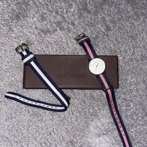 Klocka - liten - En mindre klocka från DW. En liten spricka i glaset i hörnet. Kommer i original box och ett extra armband. 