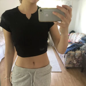 Croppad t-shirt - Croppad t-shirt med en liten öppning vid kragen. Materialet är tjockt och småribbat💕