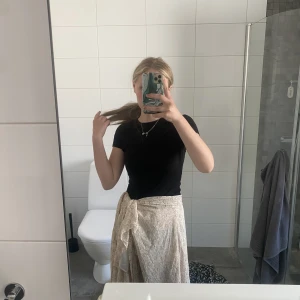 Fin lätt blommig kjol - Väldigt fin sommar kjol beige blommig, passar perfekt till sommaren, man kan själv justera lite i vilken längd (hög eller låg midjad man vill att kjolen ska vara)