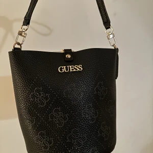Amara bucket guess - Väldigt fin guess väska från Zalando som köptes förra året för cirka 1000 kr. Inga skador på den, ser ny och fräsch ut. Säljer för 400 kr, vid snabb affär går det att diskutera priset