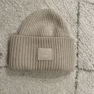 Acne mössa - Oanvänd acne mössa i beige färg 