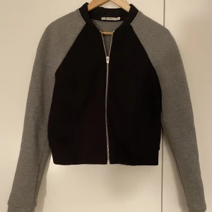 ALEXANDER WANG TRÖJA - Tröja från Alexander Wang i storlek small. Använd fåtal gånger. Svart och grå, dragkedja fram och fickor på vardera sida. 