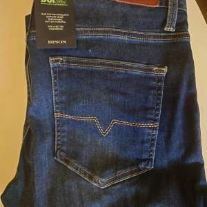 Helt nya Bison jeans i snygg mörk tvätt i storlek 32/32  och stretch kvalitet, riktigt skön modell   Org prislapp på 1000 kr samt tag kvar! Mitt pris: 199 kr plus frakt 