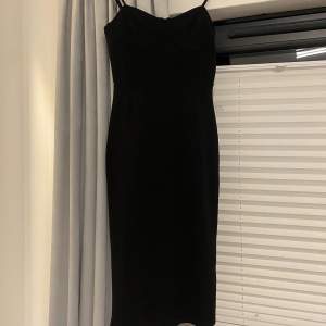 Säljer en helt oanvänd med prislapp svart klänning. Sitter tajt och formar kroppen snyggt. Den har detaljer vid brösten och längden är till knäna. Nypris 199kr säljer för 90