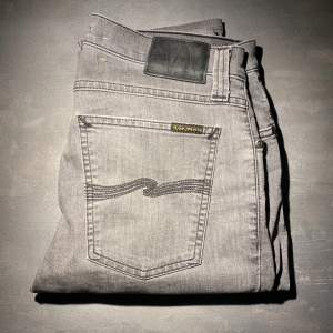 Hej 🙌🏻🤗 säljer nu ett par nudie jeans i en mörk grå tvätt. Ny pris 1400kr mitt pris 400 kr. Står stroken 30/34 men är omsydda till 30/32