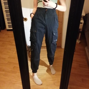 Svarta cargopants - Skit snygga cargopants som tyvärr inte kommer till användning. Sitter jätte bra och har 6 fickor varav alla är riktiga och två med käppen. Använda en del men har starkt jeans tyg och är i bra skick