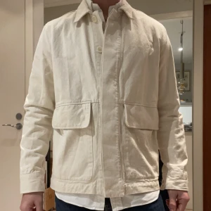 Stilren Overshirt från A Day’s March - En riktigt skön Overshirt från A Day’s March. Jag skulle säga att den är vit men lite mer åt det krämvita hållet. Den är i riktigt bra skick! Säljs billigt!!  Hör av dig om du har några funderingar!