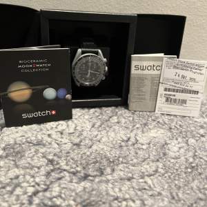 Tjena säljer denna stilrena klocka som är köpt på Zürichs flygplats i Swatch butiken där! Detta är modellen ”Mission to the moon” och är helt ny aldrig uttagen från lådan, allt medföljer(har kvitto också). Klockan är 42 MM och passar alla!