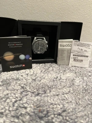 OMEGA X SWATCH - Tjena säljer denna stilrena klocka som är köpt på Zürichs flygplats i Swatch butiken där! Detta är modellen ”Mission to the moon” och är helt ny aldrig uttagen från lådan, allt medföljer(har kvitto också). Klockan är 42 MM och passar alla!