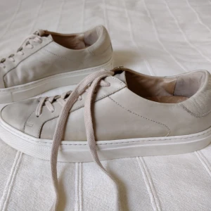 Rizzo - beige sneakers/skor i skinn/läder - storlek 40 - Beige sneakers från Rizzo. Mjuka och sköna med skinn både in- och utvändigt. Sparsamt använda - yttersulan lite sliten baktill och lädret lite flammigt/missfärgat (syns mer på bilderna med blixt). Går kanske fixa med läderbalsam. Storlek 40.
