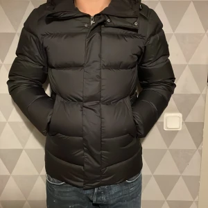 J.Lindeberg Bane Down Jacket - Svart - hej! Säljer nu denna varma och sköna jacka från J.Lindeberg.  storleken är xs men passar s. skicket är fint och tveka inte på att kontakta mig med följande frågor. 🙌