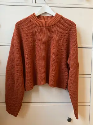 Stickad tröja från Gina Tricot, orange/röd i färgen. Storlek M, passar XS-M beroende på hur man vill att den ska sitta. Något croppad i modellen.