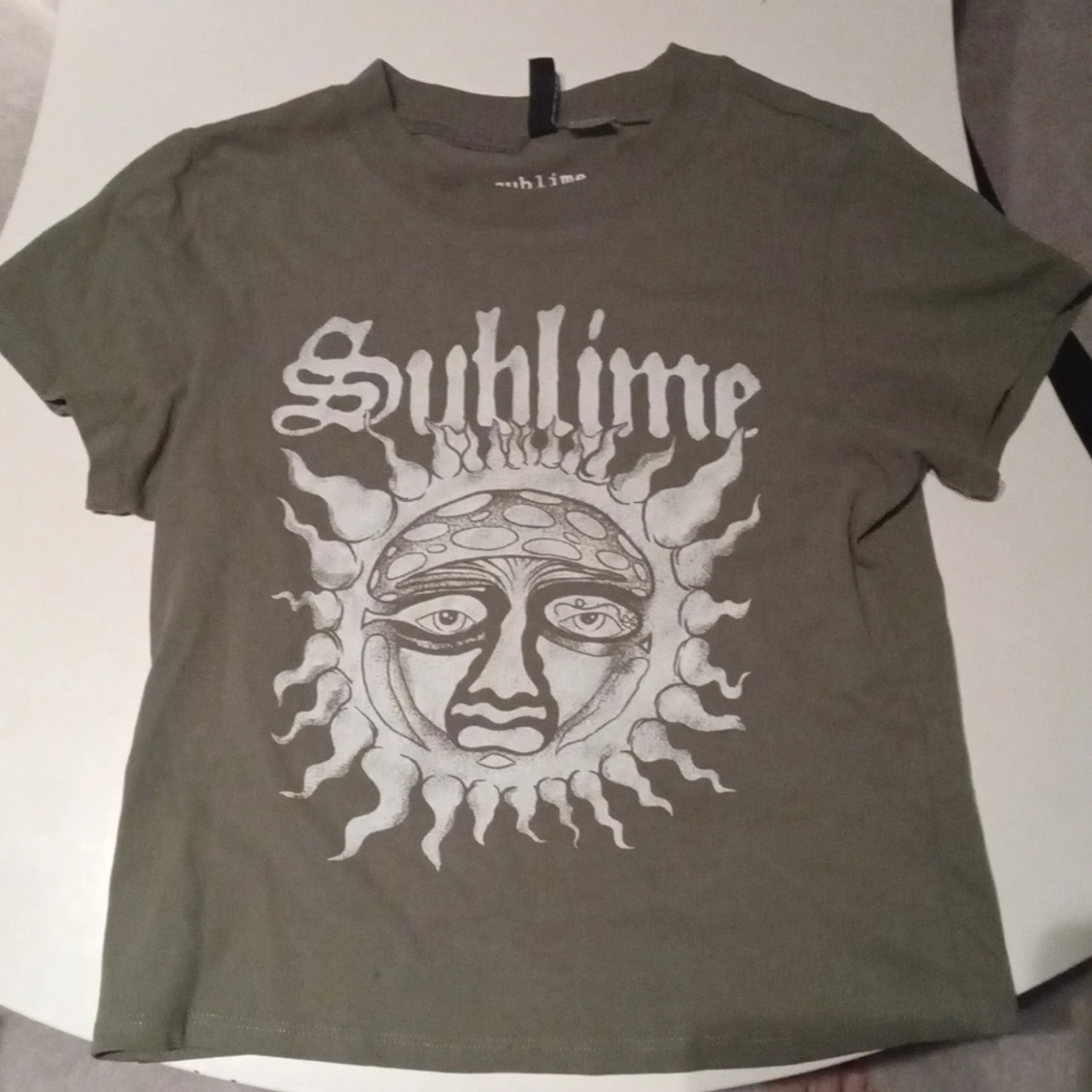 En militär grön tröja med en sol