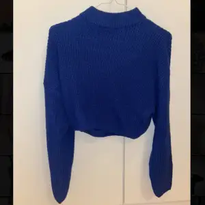 En croppad mörkblå stickad tröja ifrån HM. 