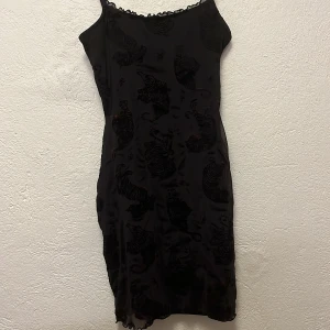 Svart klänning  - Svart klänning. Använd men i bra skick. Är mönstrad med tigrar i svart. 