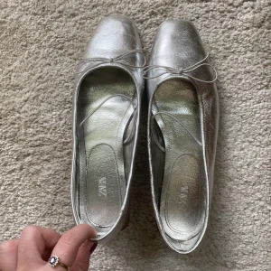 Silver ballerina skinn  - Mycket sparsamt använda ballerina. Märkta storlek 37 men jag tror de kmr sitta bättre på någon som har 38. Helt slutsålda på hemsidan! 