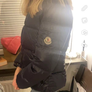 moncler maya barn  - jacka från moncler i modellen maya,strl 12år men passar xs! den är väldigt använd och slitningar finns därav pris! serien i har losnat o finns några små hål på insidan luvan finns ej! den e gml så finns ej qr kod men har äkthetsbevis från vestiaire! 