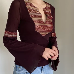 Vinröd topp - Bohemisk vinröd topp med vacker urringning och utsvänga ärmar. Uppskattad storlek. 