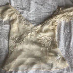 Helt ny gräddvit topp från Asos - Gräddvit topp med spets utställda ärmar och dekorativ sömn . Helt ny från Asos - hann inte göra returen i tid . Köpt för 345:- säljer för 250:- 