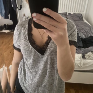 Tröja med spets  -  Grå t-shirt med svarta spets detaljer, bra skick