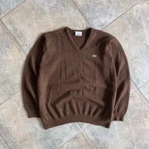 Lacoste stickad tröja - Grymt snygg tröja i perfekt skick. Äkta lacoste, så bra kvallité. Materialet är 100% merinoull, ett material som håller värmen bra men ändå andas. Passar herr S, dam s-m. Öppen för bud, och ger alltid rabatt vid köp av fler plagg. 