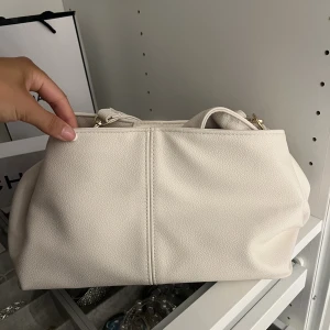 Vit/beige väska - Vit/beige (krämvit) väska för endast 150kr. Super fin och bra med utrymme.