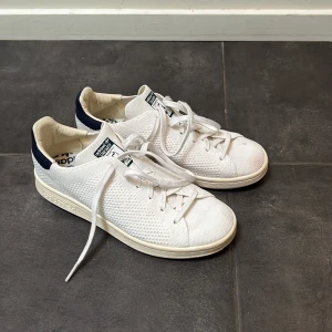 Vita adidas sneakers  - Säljer ett par vita Adidas sneakers, de är använda och har några ljusröda fläckar på tårna (bild 3) därav priset. Vid snabb affär kan priset diskuteras.