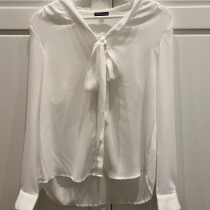 Vit blus med knytning - Säljer denna fina blusen från STOCKH LM med supersöt knytning där framme då den inte används. Materialet är jätteskönt och den passar till allt. Hör av dig vid intresse!