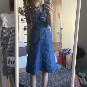 Hängselklänning i jeans - Vintage hängselklänning från 70-talet i toppenskick och fantastisk kvalitet💙Fickor bak, fram och på bysten