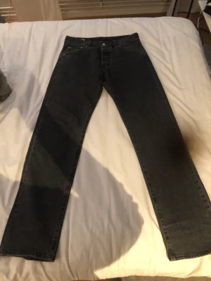 Mörkgråa Levis 501 - Levis 501, jeansen är använda ett par gånger men är fortfarande i bra skick. Nypris 1100kr.