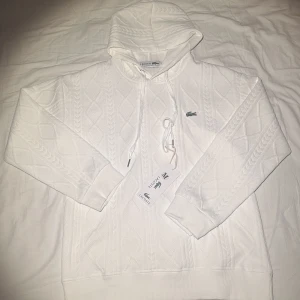 Lacost hoodie  - Vit lacost hoodie jätte skön men köpte fel storlek. Det är en storlek M men den är väldigt kort i armarna för att vara storlek M 