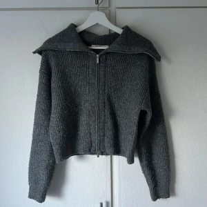 Stickad kofta - Grå stickad kofta från NAKD. Mysigt och skönt material som inte sticks. Använd ett antal gånger och blivit lite flocklig (se bild), men annars i fint skick.  Storlek M