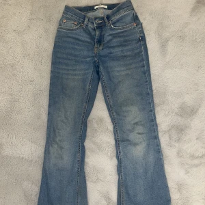 Low waist jeans - Ett par lågmidjade blåa bootcut jeans från Gina tricot, köpte dessa för 500 kr  och färgen ser lite konstig ut på bilden pga av ljuset, dom sitter jättefint på midjan. Annars så sitter dom jätteskönt på. Säljer pga dom kommer aldrig till användning.