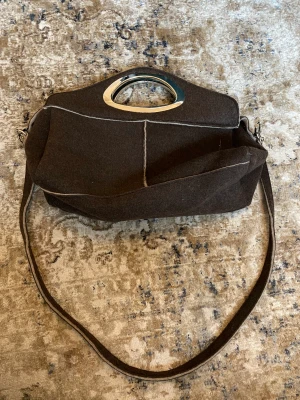 Väska i lyxigt material - Super fin väska i härligt material med snygga sömmar. Nästan helt oanvänd, lagom stor. Kan både bäras på axeln och ha i handen 