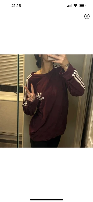 Adidas tröja - Långärmad vinröd/mörklila tröja från Adidas. Köpte den i storlek L för ville ha den oversized. Men går även att ha den som på bild 2 genom att tex knyta den