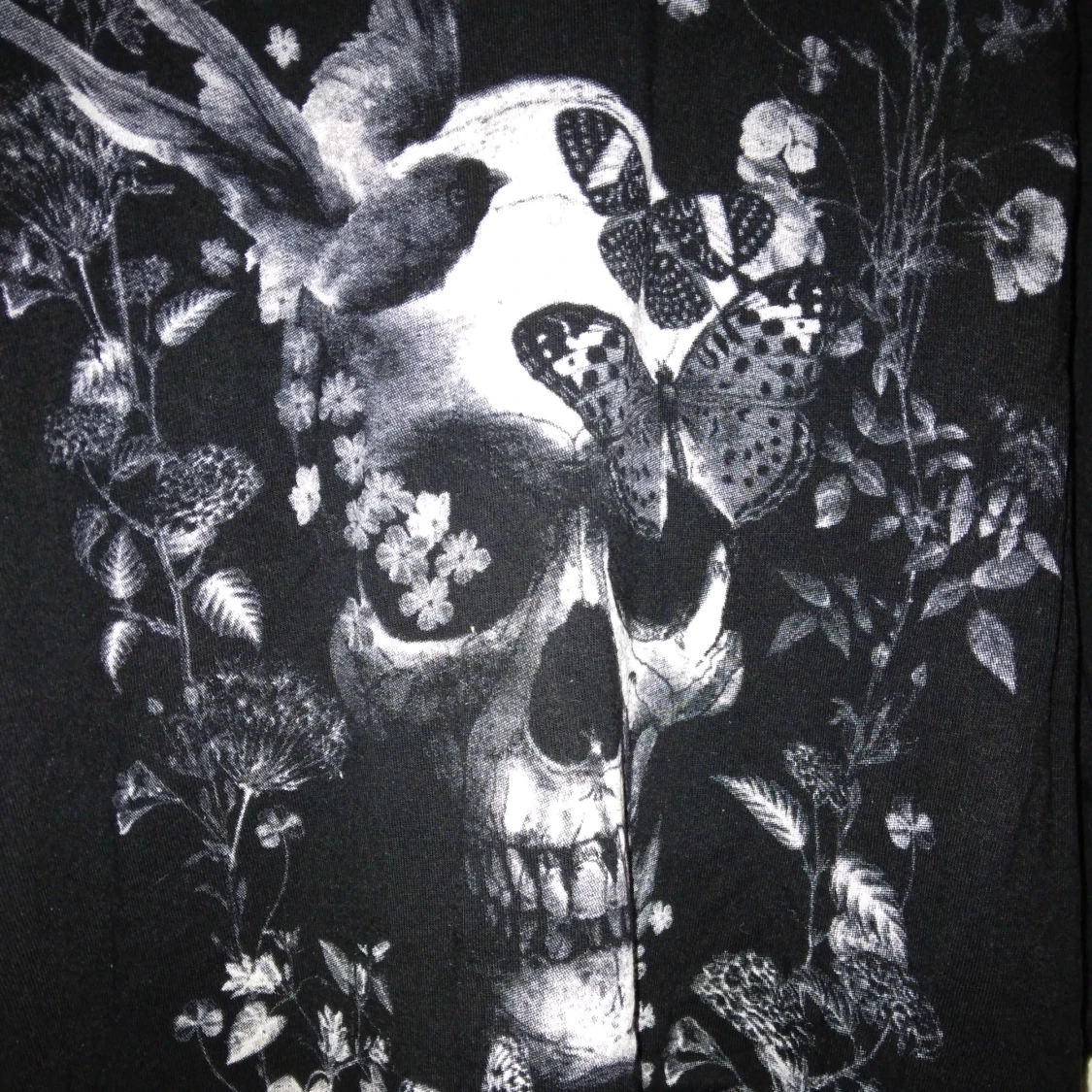 Svart längre topp med avklippta ärmar / linne. Döskalle tryck. Mjuk viskos. Strlk: XS-SMALL. Gina Tricot.