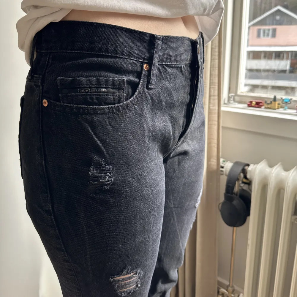 Svarta mid waist jeans med slitningar från Calvin Klein.  Storlek: L32/W32  Använd några gånger.. Jeans & Byxor.