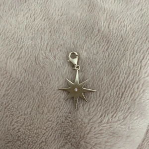 Berlock - Silver berlock som föreställer en stjärna. Den är lite rostig men inget som syns på långt hål. Köpt för 98 kr på guldfynd.